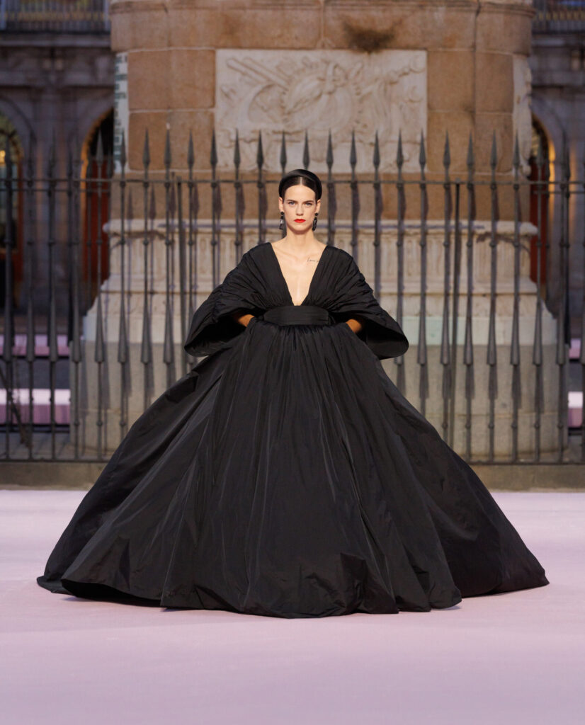woman walking the runway in a black carolina herrera dress