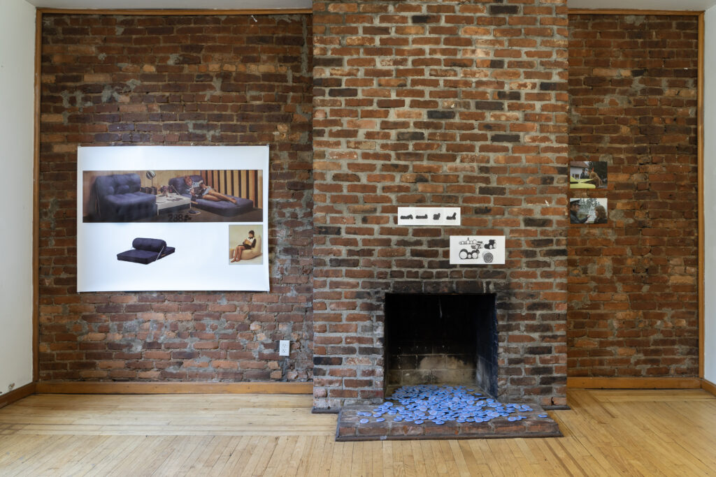 Interior of apartment featuring film stills, furniture designs, IKEA catalog graphics, and IKEA pins piled in a fireplace.