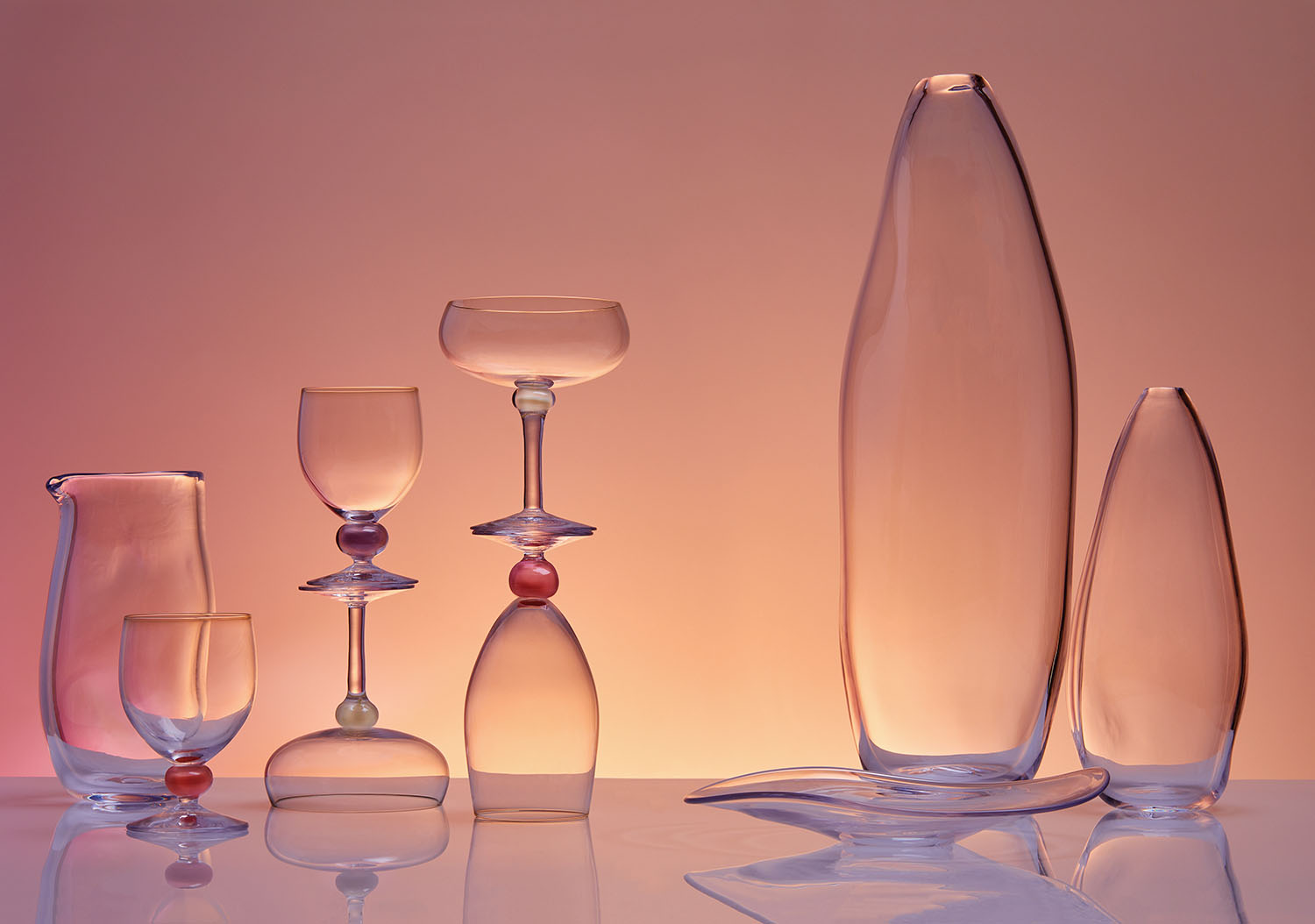 From left to right: Mardahl Pitcher, Wine Glass in Rhubarb, Wine Glass in Plum, Champagne Glass in Coconut, Water Glass in Rhubarb, Small Serving Dish, Large Skinny Vase, and Small Skinny Vase. 