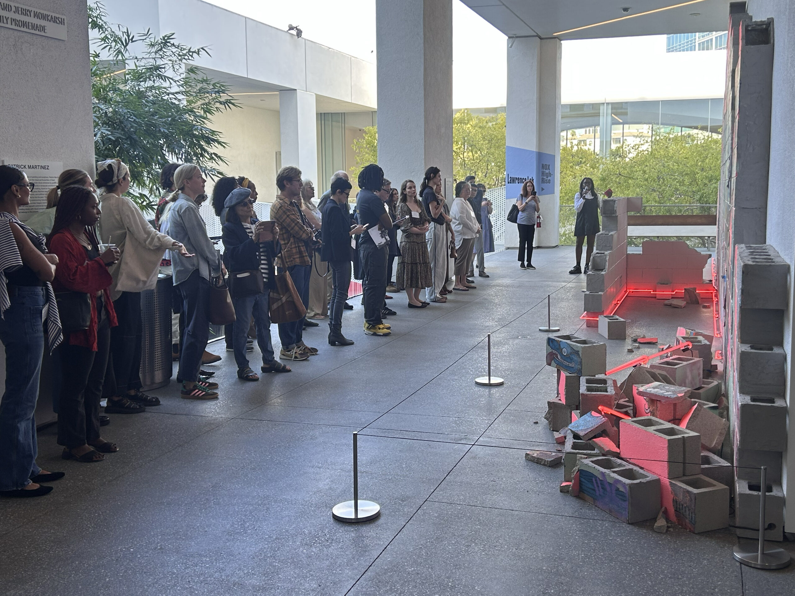 Essence Harden leading a tour during the press preview for "Made in L.A. 2025," featuring Battle of the City on Fire, 2025, by Patrick Martinez