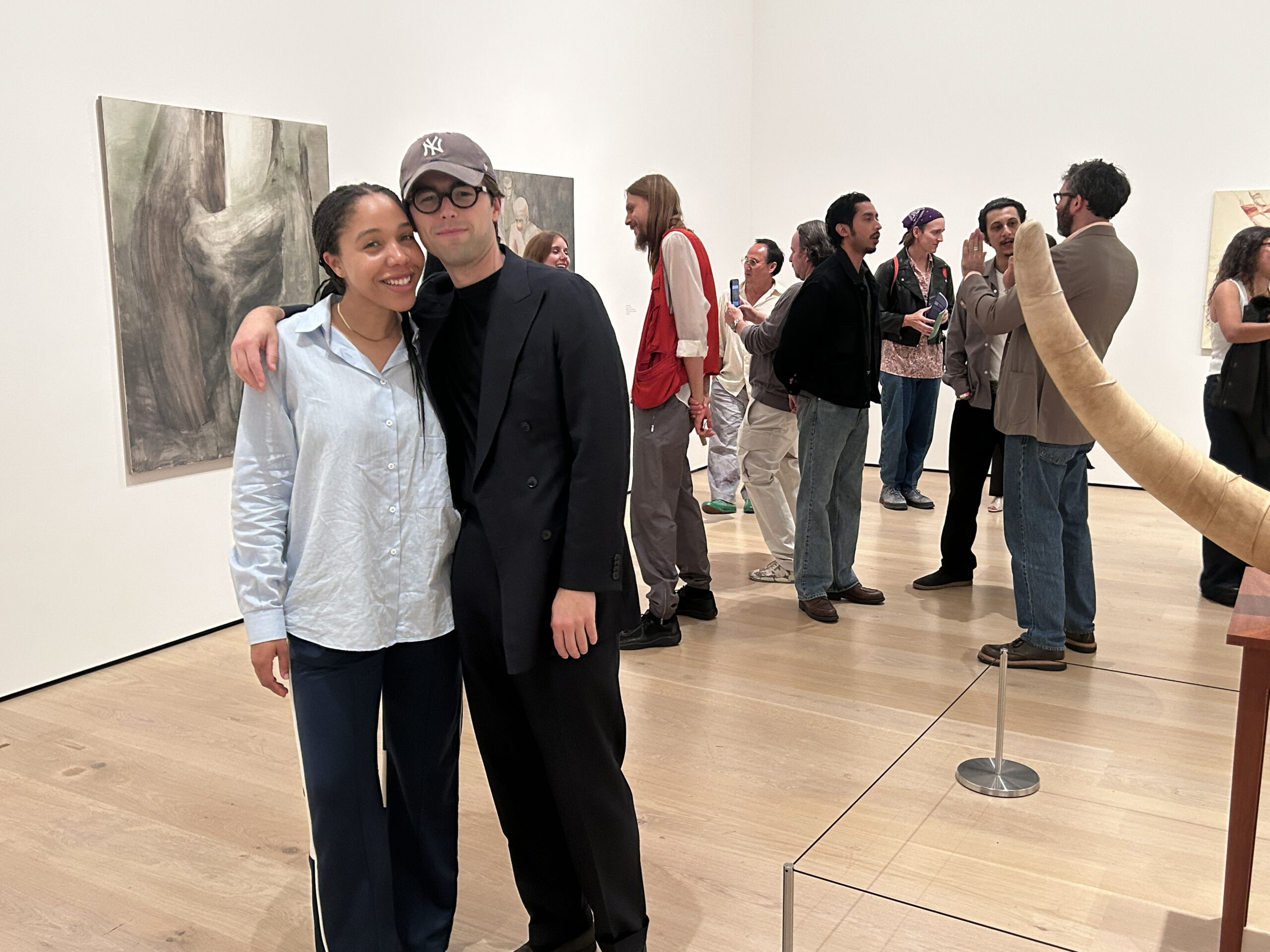 From left: Adrianna Cole, Harrison Glazier. Background: artist Artem Nanushyan (in red) talks to Athena Denos; artists Mario Ayala and Ryan Preciado listen to Sebastian Gladstone