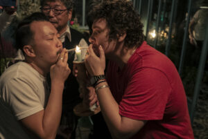 Tommy Kha and Elle Pérez light a cigarette on a candle