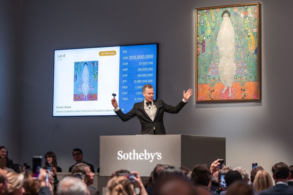 A middle aged man leads an auction of Gustav Klimt's Portrait of Elisabeth Lederer at Sotheby's.