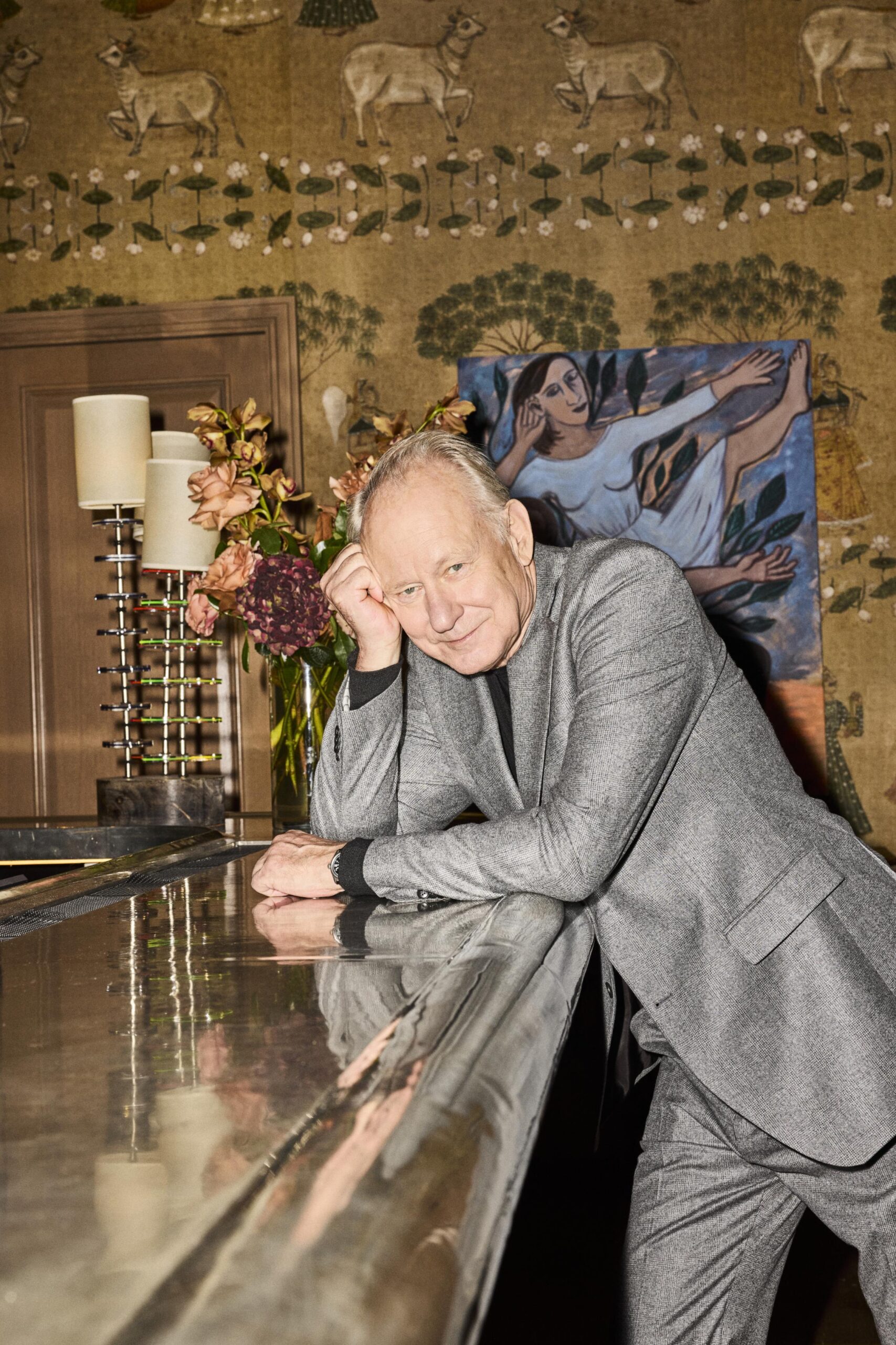 Portrait of Stellan Skarsgard by Jeremy Liebman in a bar setting with painting behind the subject, interviewed by Robert Reich