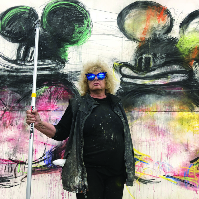 Joyce Pensato next to Mickey Mouse mural.