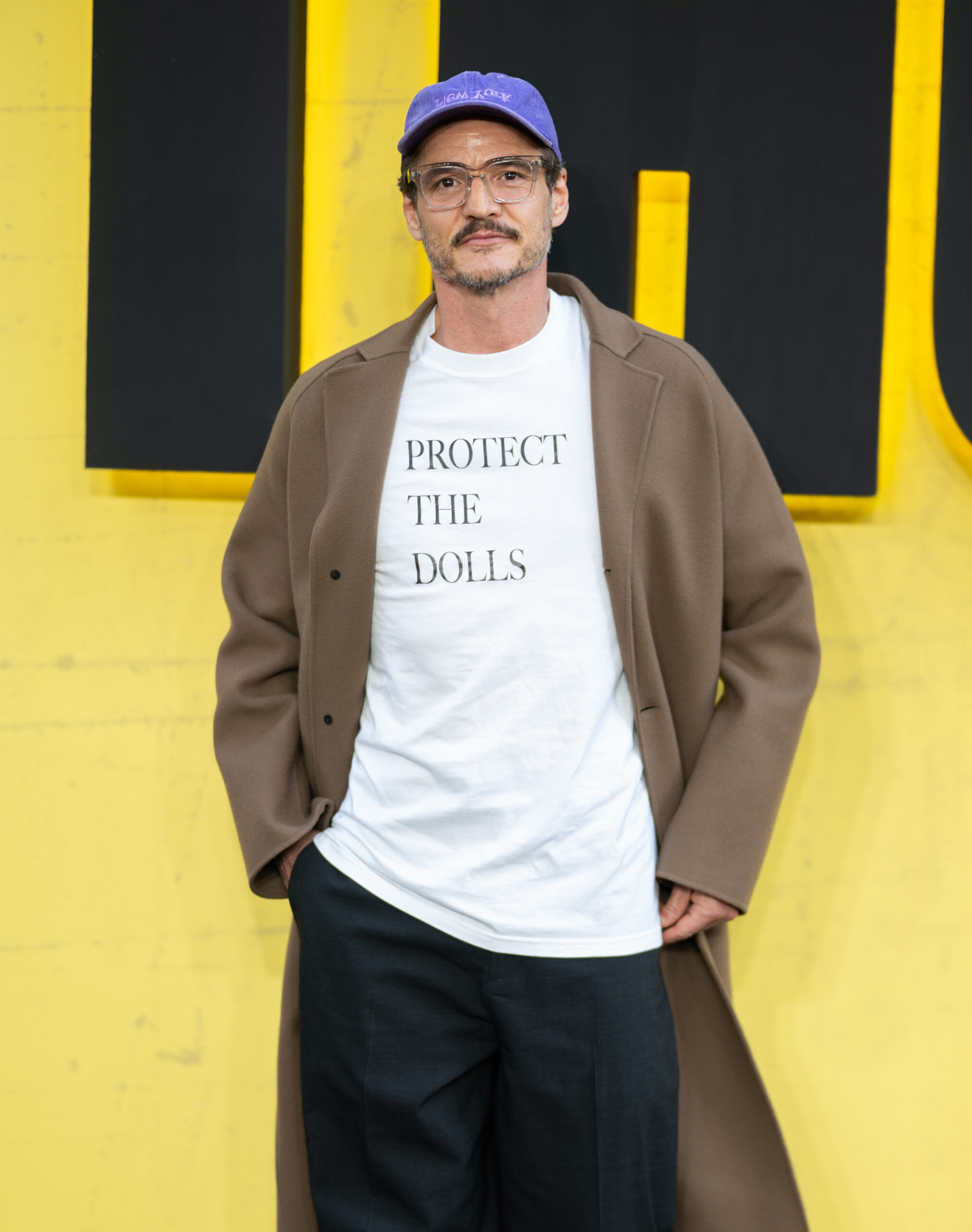 Pedro Pascal in a "Protect the Dolls" white t-shirt by Samir Hussein/WireImage, and courtesy of Getty Images