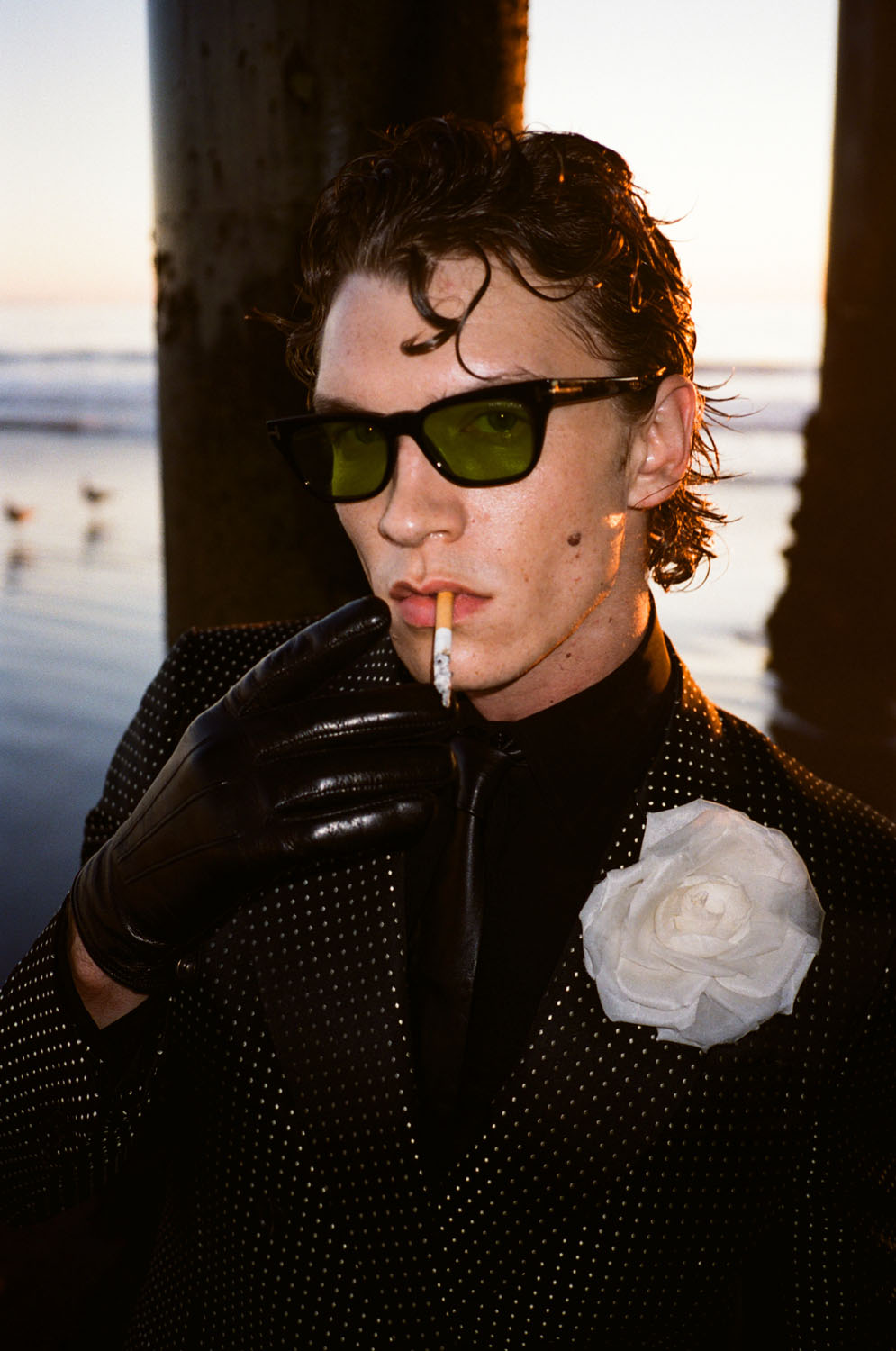 Connor Storrie wears a full look by Tom Ford at the beach