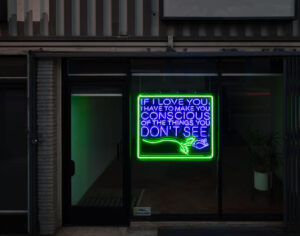 A neon sign by artist Patrick Martinez reads “If I love you, I have to make you conscious of the things you don’t see."