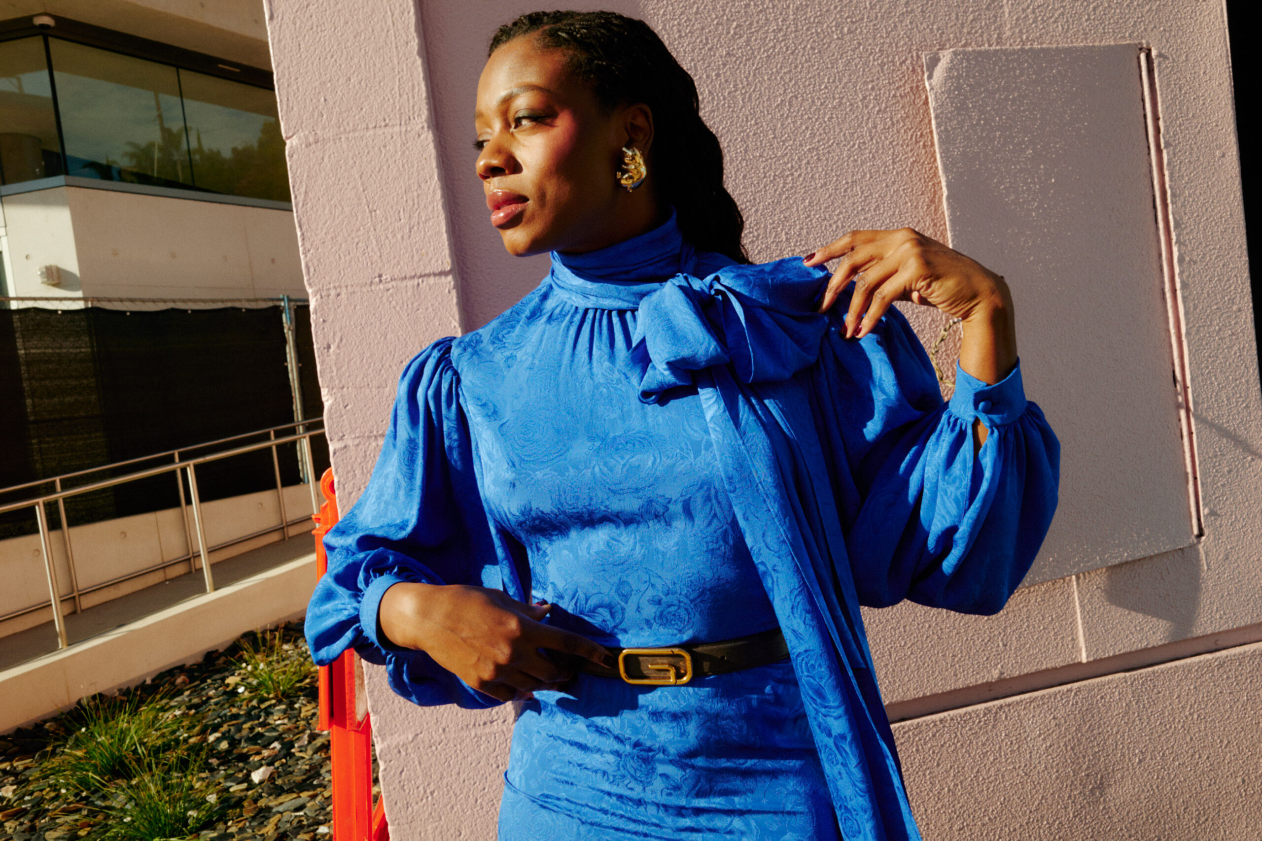 Director Nia DaCosta shot by Brad Torchia, Nia wears a dress, belt, and earrings by Gucci