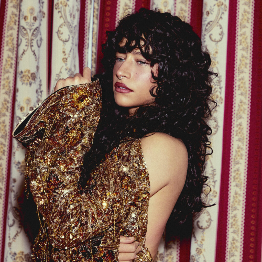 Actress Odessa A'zion wears a gold sparkly jacket by Gucci.