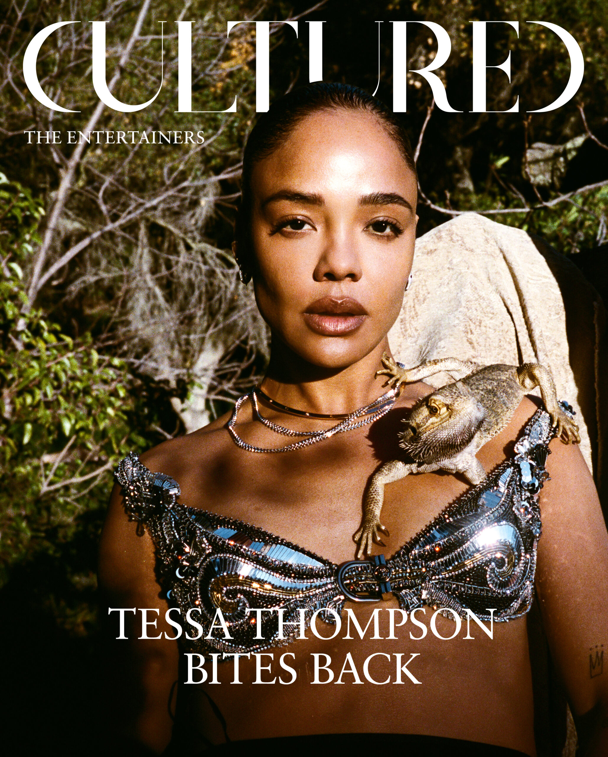 Actress Tessa Thompson of Hedda and His & Hers poses in a silver Versace bra with a bearded dragon.