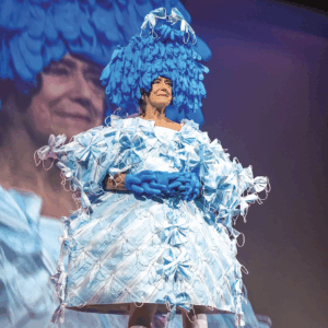 Artist Pat Oleszko wears a fantastical dress made from masks for her performance Masked Mandate.