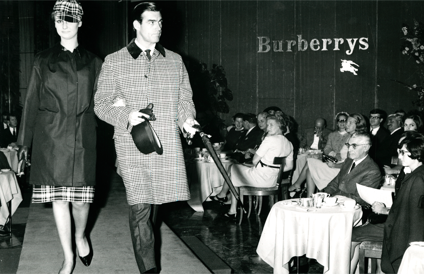 A black and white photo of a vintage Burberry runway show in the 1960s in Milan.