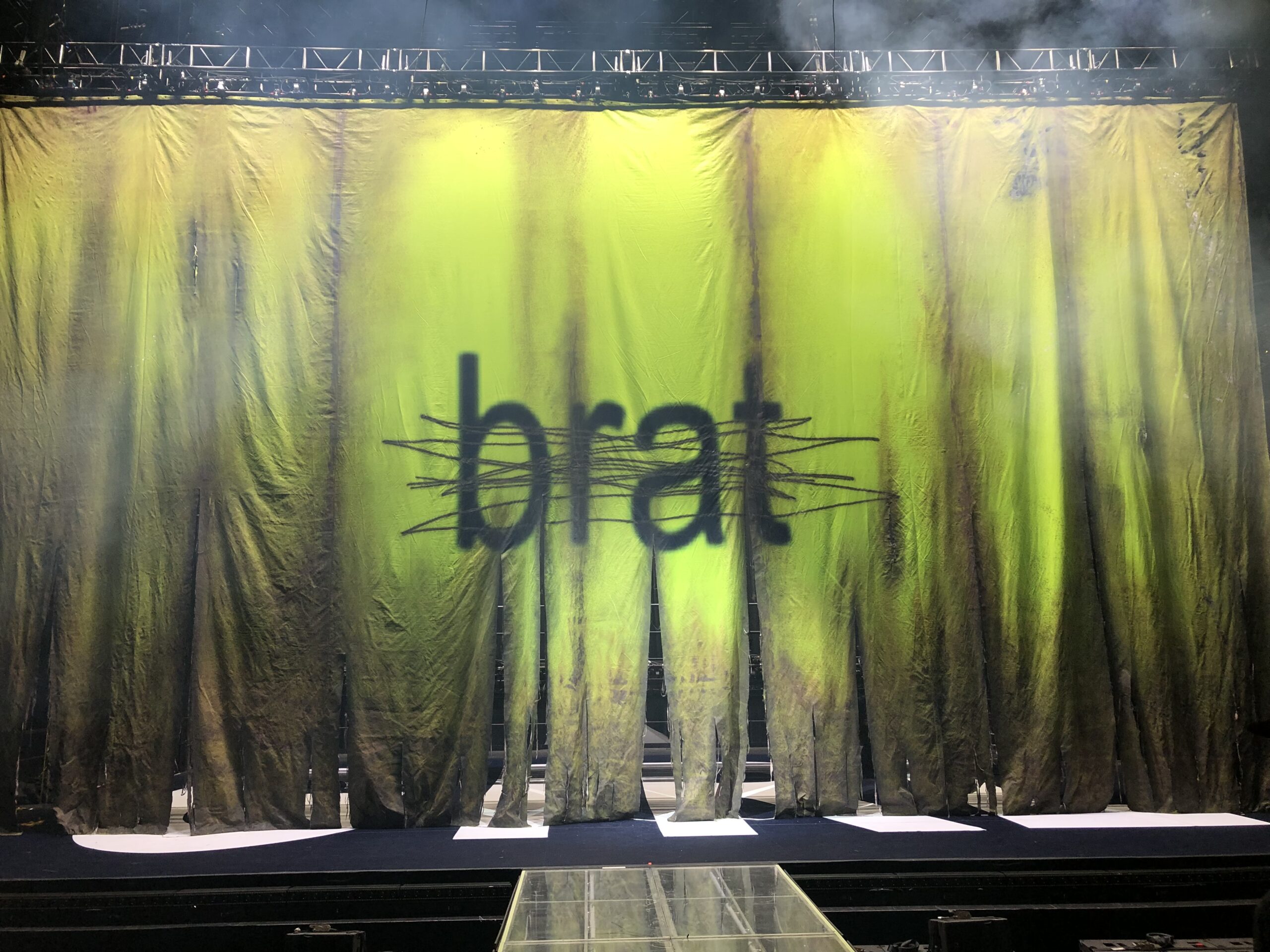 A banner with the cover of the Charli XCX album brat, with the letters crossed out