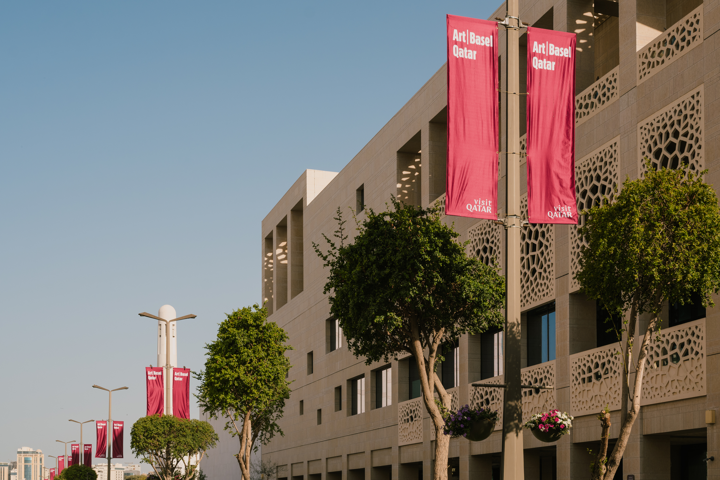 Red banners with signage for Art Basel Qatar wave in Doha