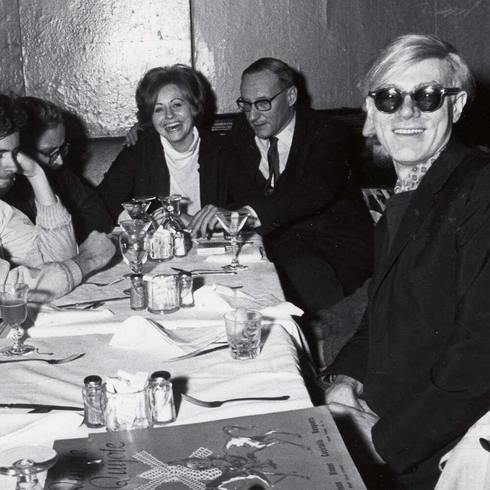 Andy Warhol and friends sit for a meal at the Chelsea Hotel