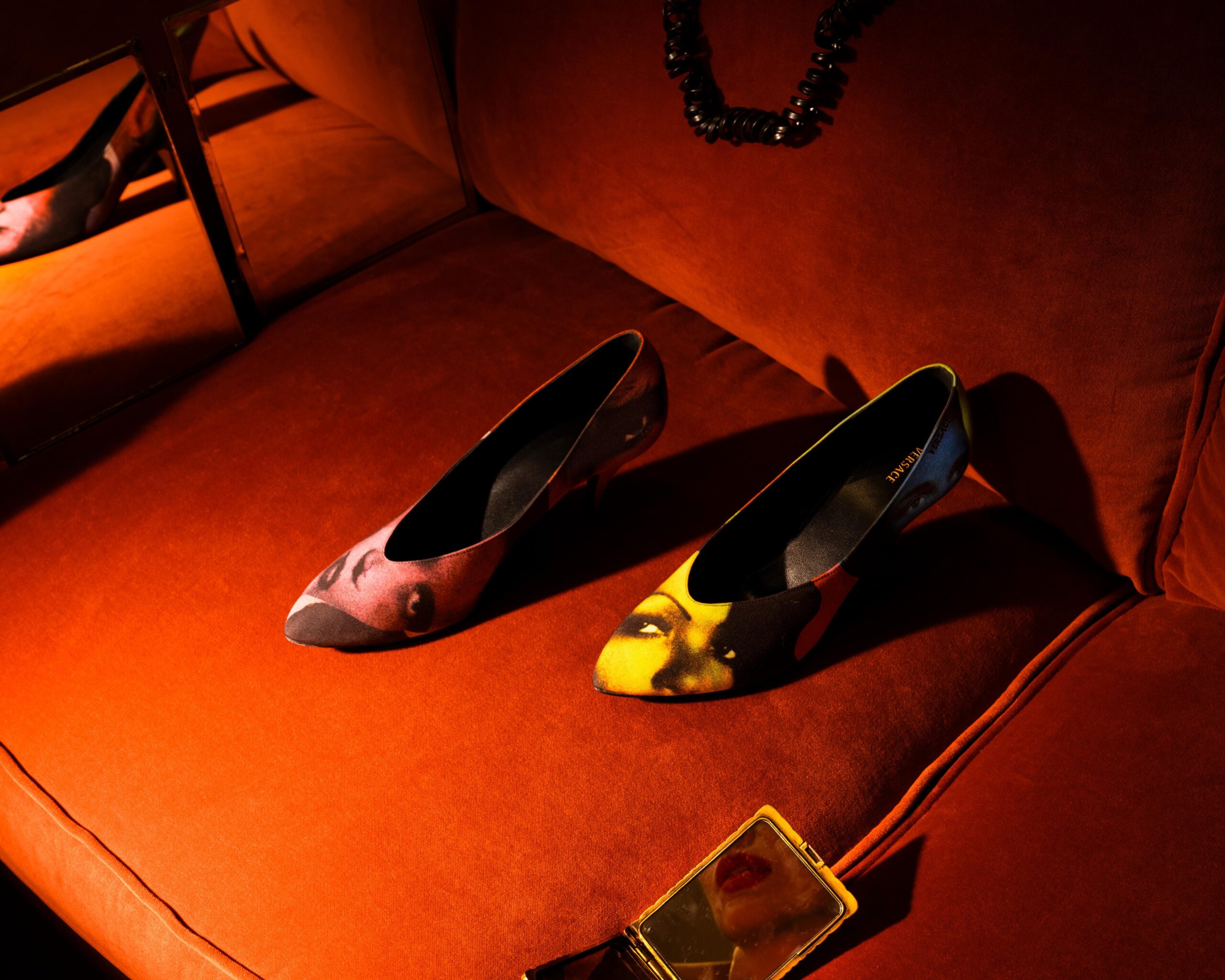 versace-ss26-campaign-tania-franco-klein Two alternating pairs of printed shoes appear on orange seating in Versace's Spring/Summer 2026 campaign shot by Tania Franco Klein