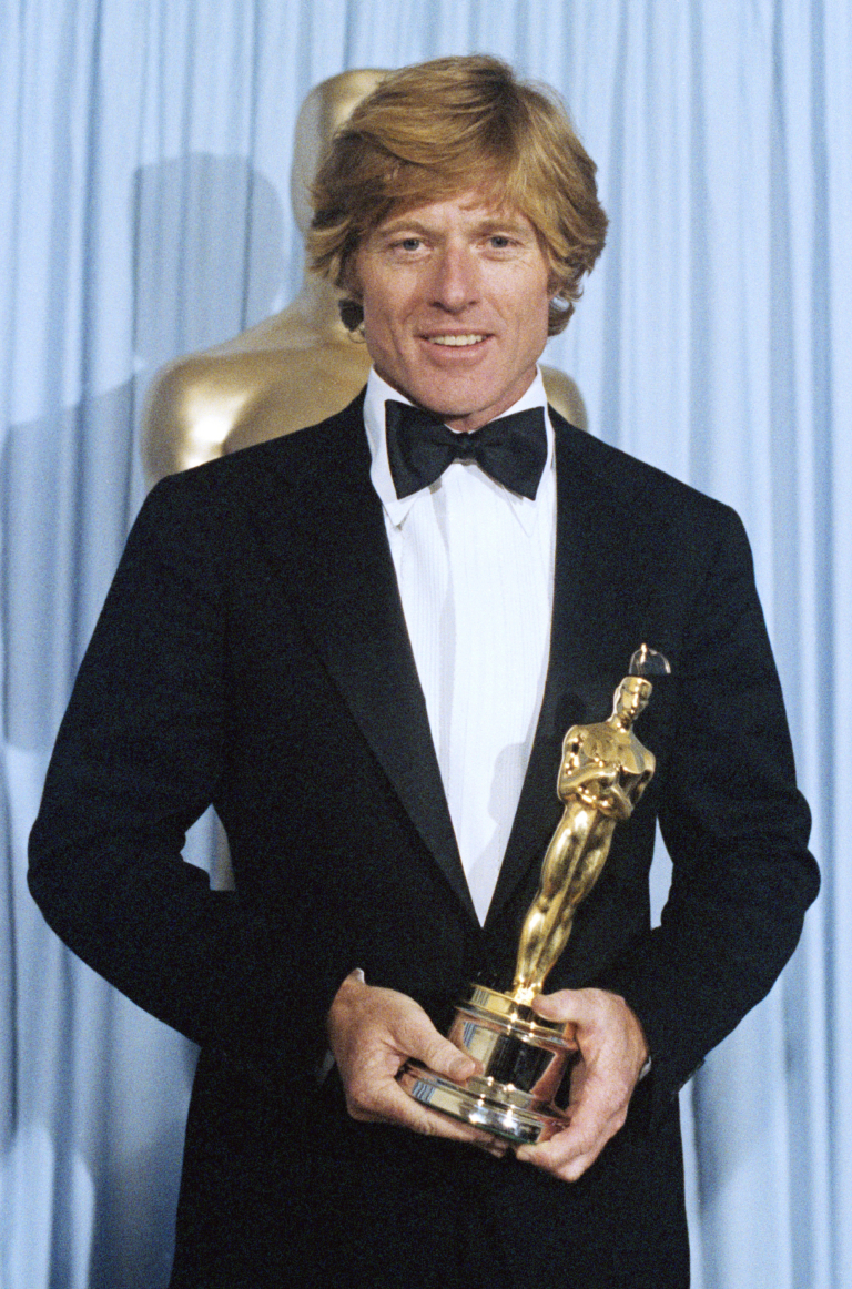 Robert Redford poses for a portrait with his award at the Academy Awards