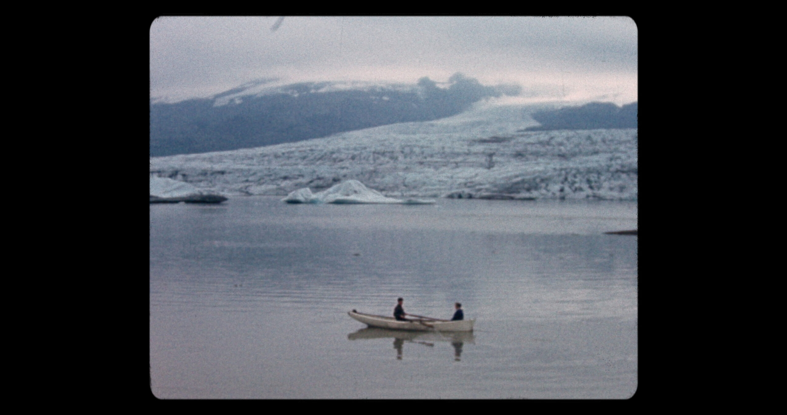Still of two people on a row boat in a glacial lagoon from Time and Water, 2026