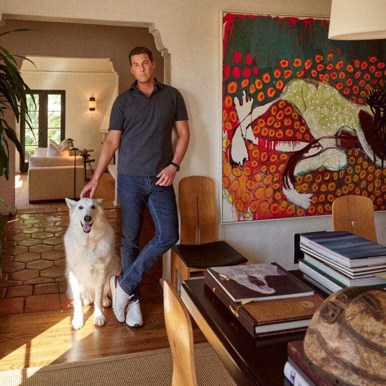 Will Bennett poses for a portrait at home with his dog