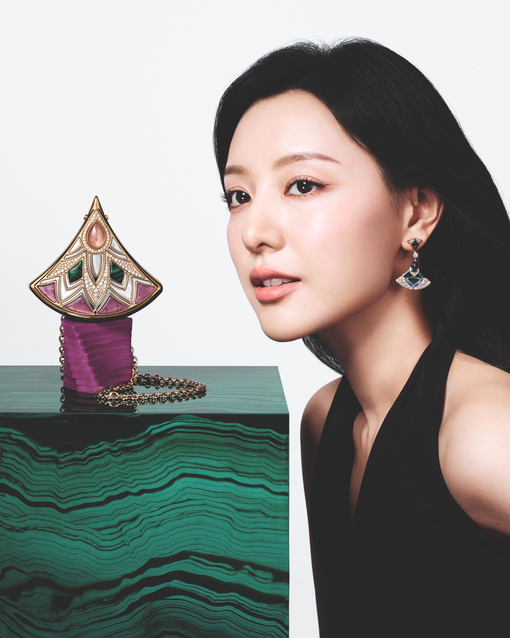 Kim Ji-Won poses with the Divas' Dream minaudière resting on a green pedestal