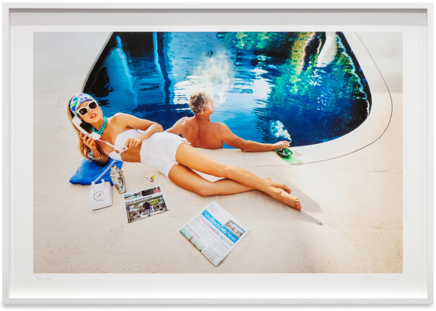 woman lying next to a pool, man sitting in pool
