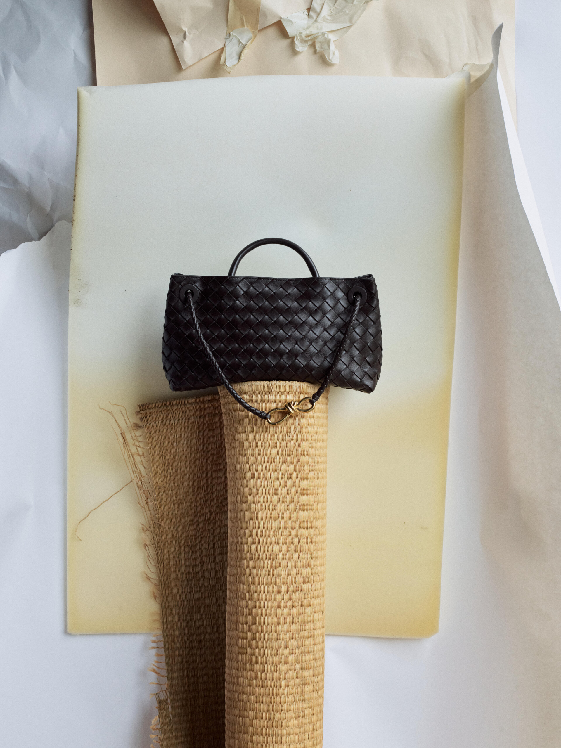 The Bottega Veneta Andiamo resting atop a woven mat